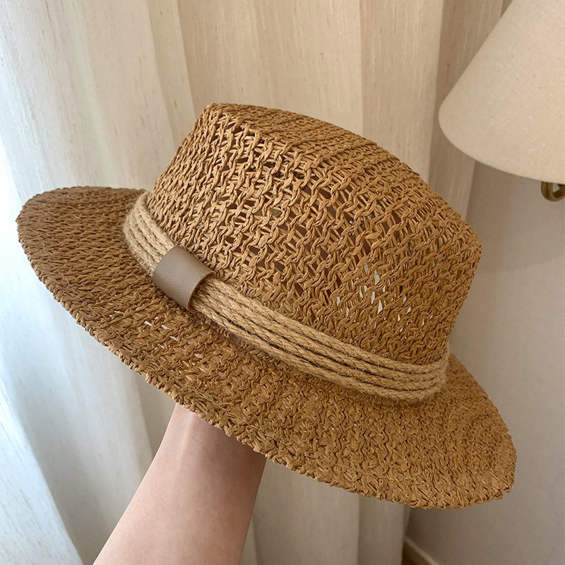 A Vintage Summer Getaway in France by The Beach, Featuring a Classic Flat-Topped Straw Hat from a Wealthy Background, Along with a Retro Hand- Sun Hat for Protection